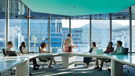 A diverse group of professionals in a conference room, engaged in a meeting on sustainability.